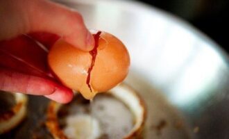 В каждое из луковых колец разбиваем яйцо.