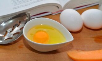 Яйцо аккуратно разбиваем в чашку, желток должен остаться целым.