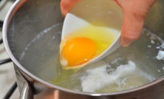 Очень осторожно выливаем яйцо в воду.