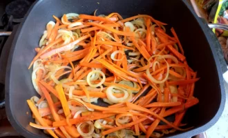 Морковь нарезаем тонкими полосками. Добавляем на сковороду к луку. Обжариваем до золотистого цвета.