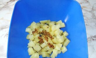 Картофель чистим, режем кубиками. Добавляем соль, горчицу, растительное масло, перемешиваем и оставляем на минут 15 настояться.